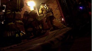 Firefighters masking up to make entry into the structure.
